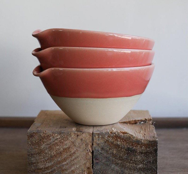A ceramic bowl with an indented lip for easy pouring. 