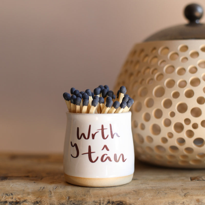 A small ceramic pot filled with matches