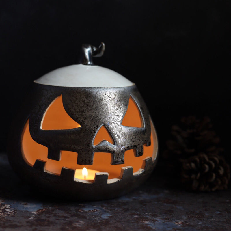 A glazed ceramic lantern pot with a Jack ‘o Lantern design from Glosters pottery classes.