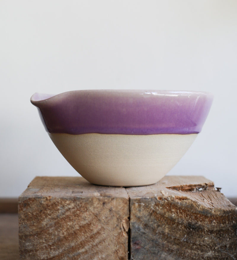 A ceramic bowl with an indented lip for easy pouring. 