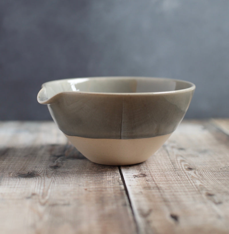 A ceramic bowl with an indented lip for easy pouring. 