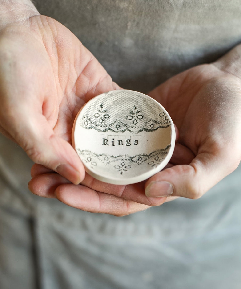 A small ceramic trinket dish with the word ‘rings’ stamped in the bowl. 