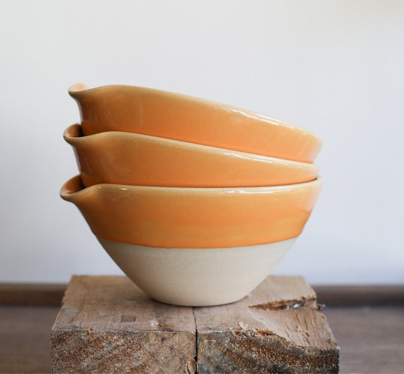 A ceramic bowl with an indented lip for easy pouring. 