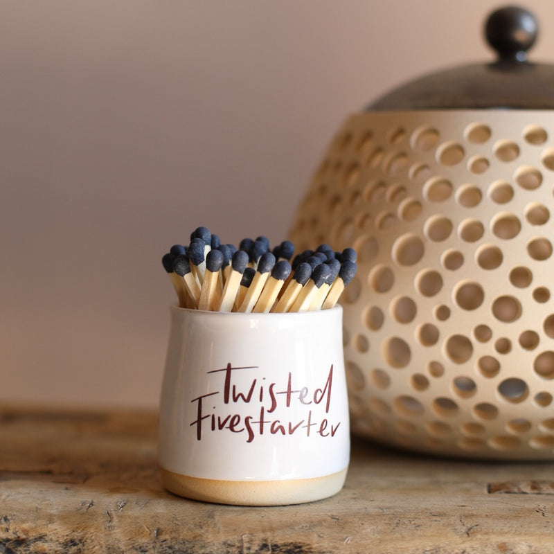 A small ceramic pot filled with matches