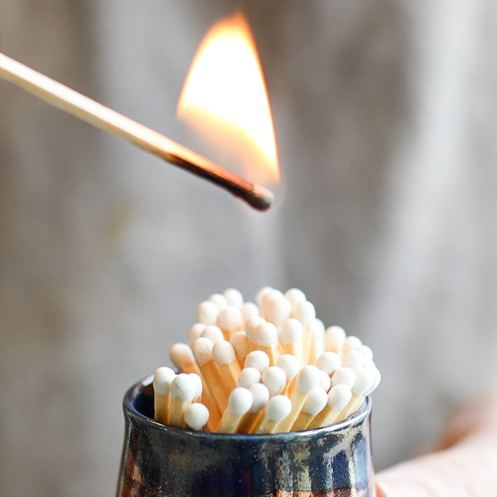 A ceramic match pot full of refilled matches.