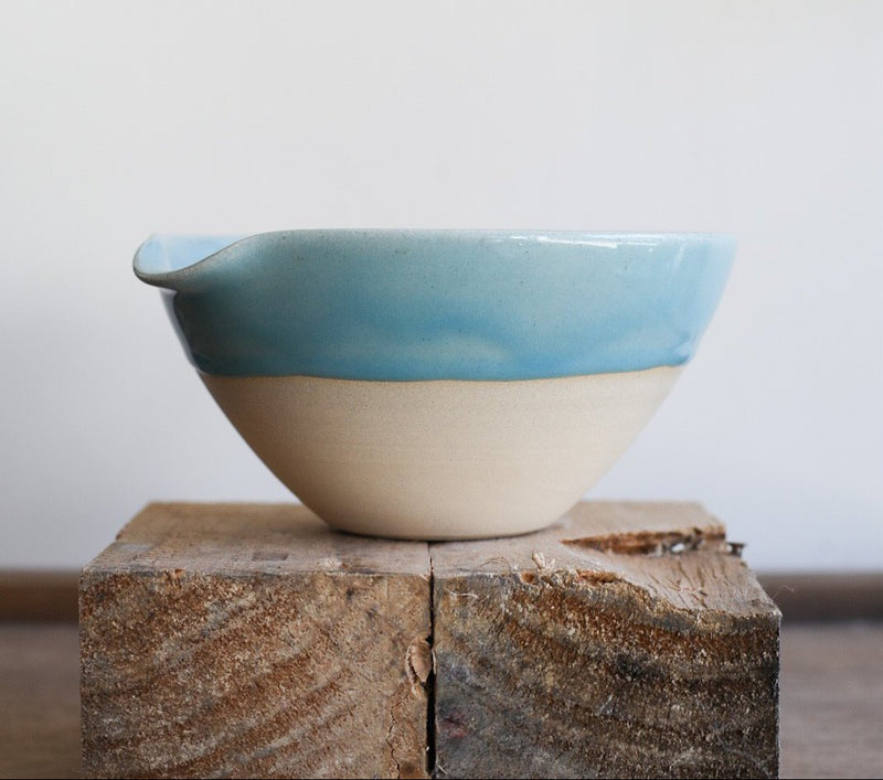 A ceramic bowl with an indented lip for easy pouring. 